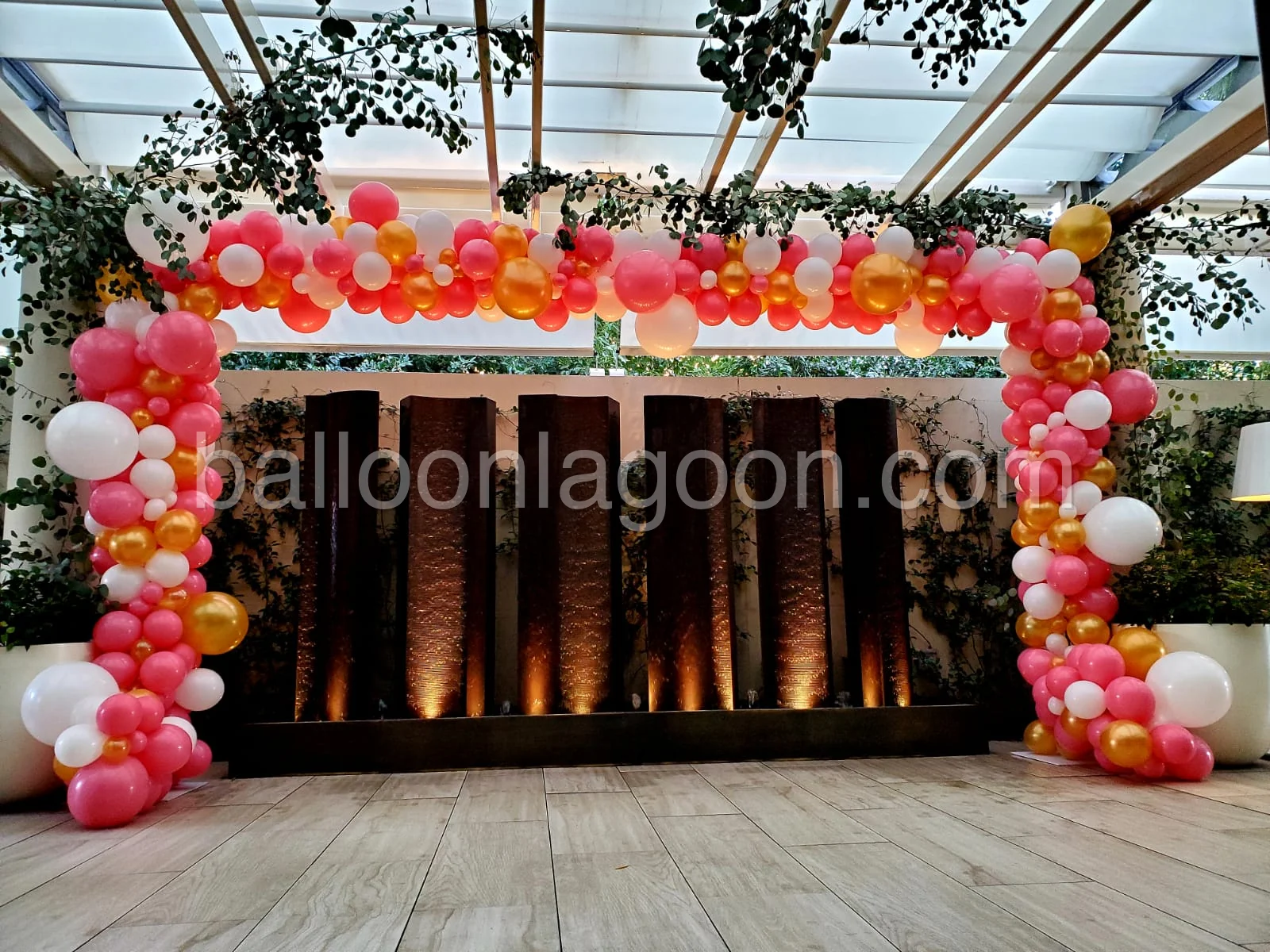 Pink, gold, and white balloon arch event installation showcasing bespoke event architecture by Balloon Lagoon
